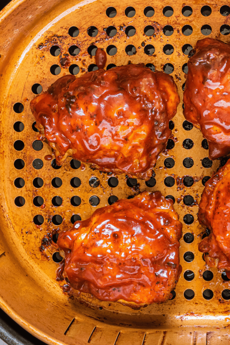 Air fryer peri peri chicken served on a plate with a small bowl of dipping sauce.