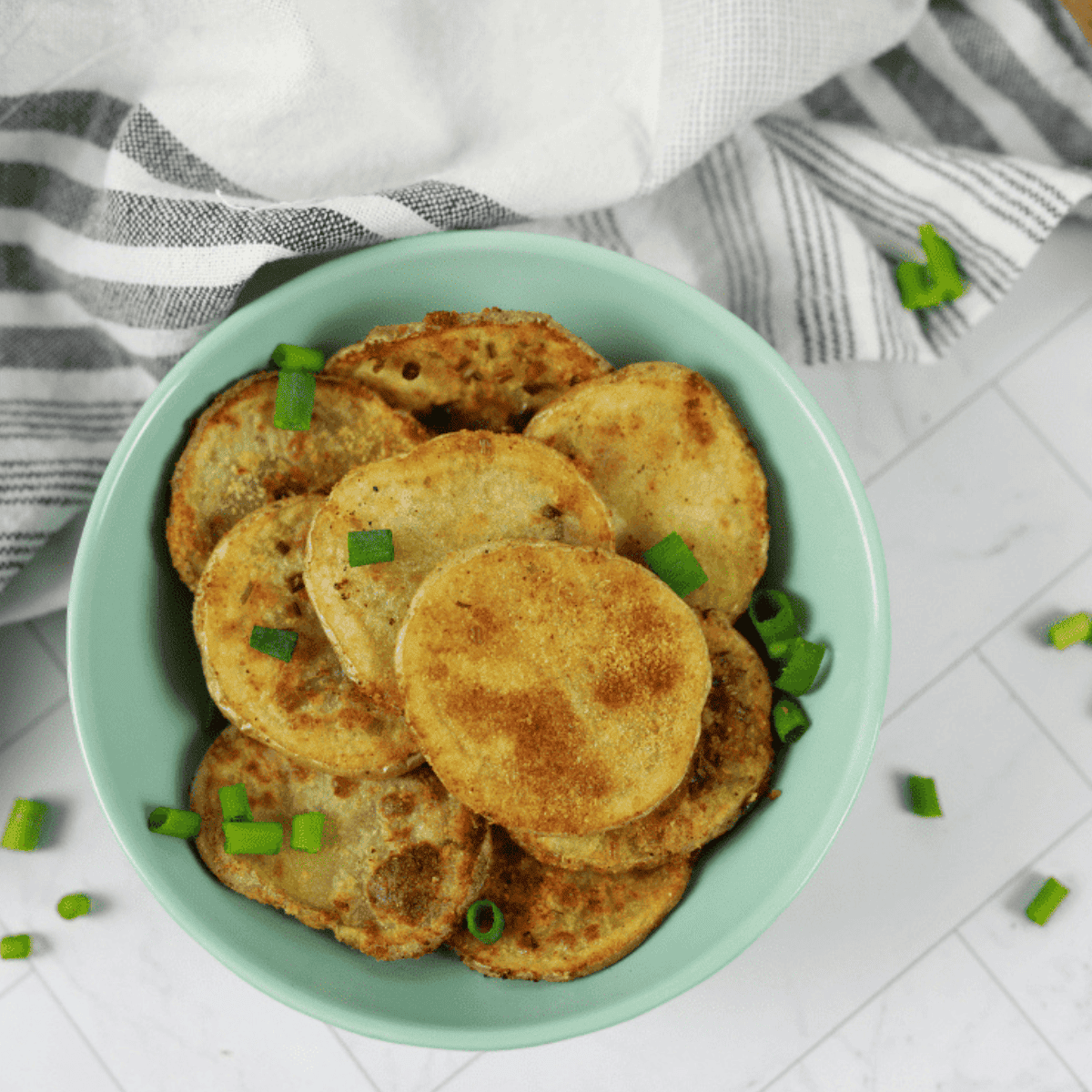 Golden, crispy air fryer sour cream and onion potato chips in a bowl.