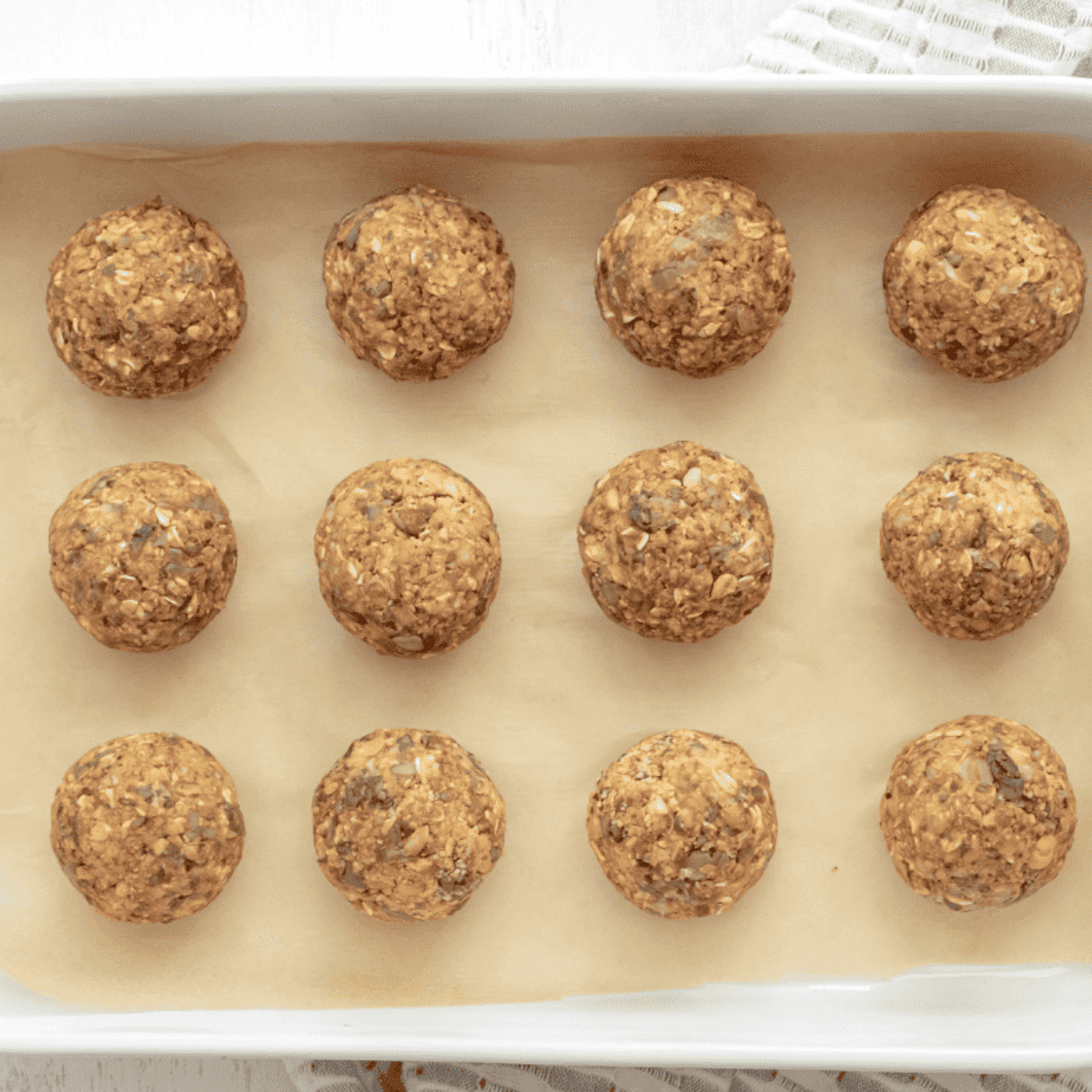 Shaping a ¼ cup scoop of vegan mixture into a round meatball on a work surface