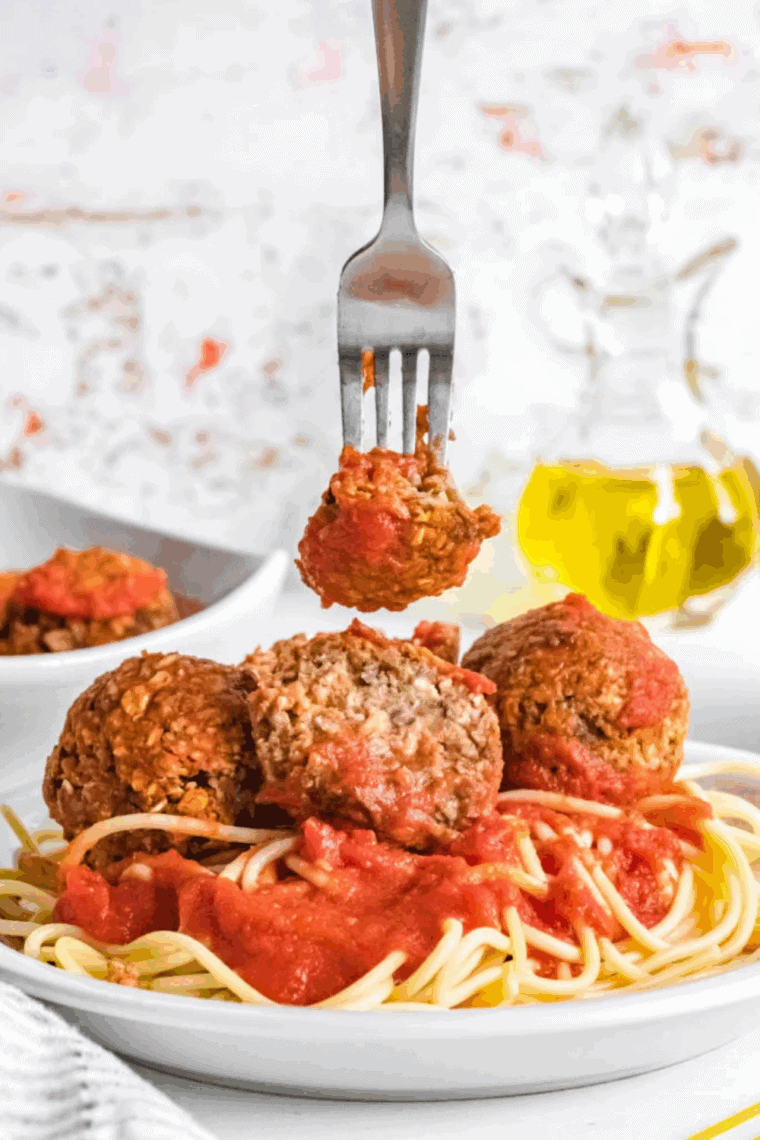 Air fryer vegan meatballs golden brown and served with marinara sauce on a plate
