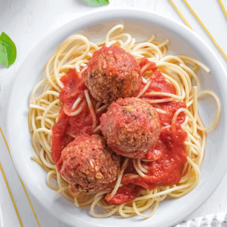 Golden-brown air fryer vegan meatballs served with marinara sauce on a plate, ready to eat