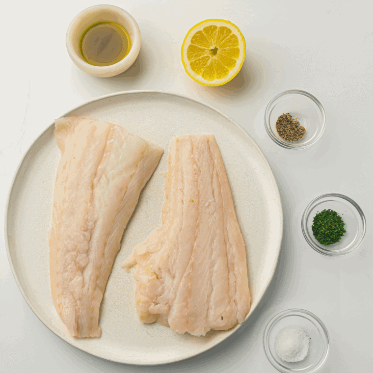 Patting cod fillets dry with paper towels and coating with olive oil for seasoning adherence