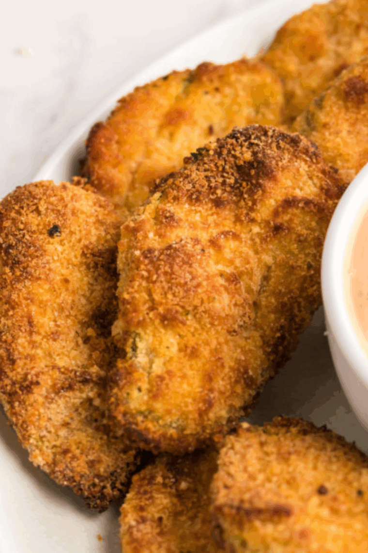 Golden, crispy Hooters-style fried pickles fresh from the air fryer, served with dipping sauce.