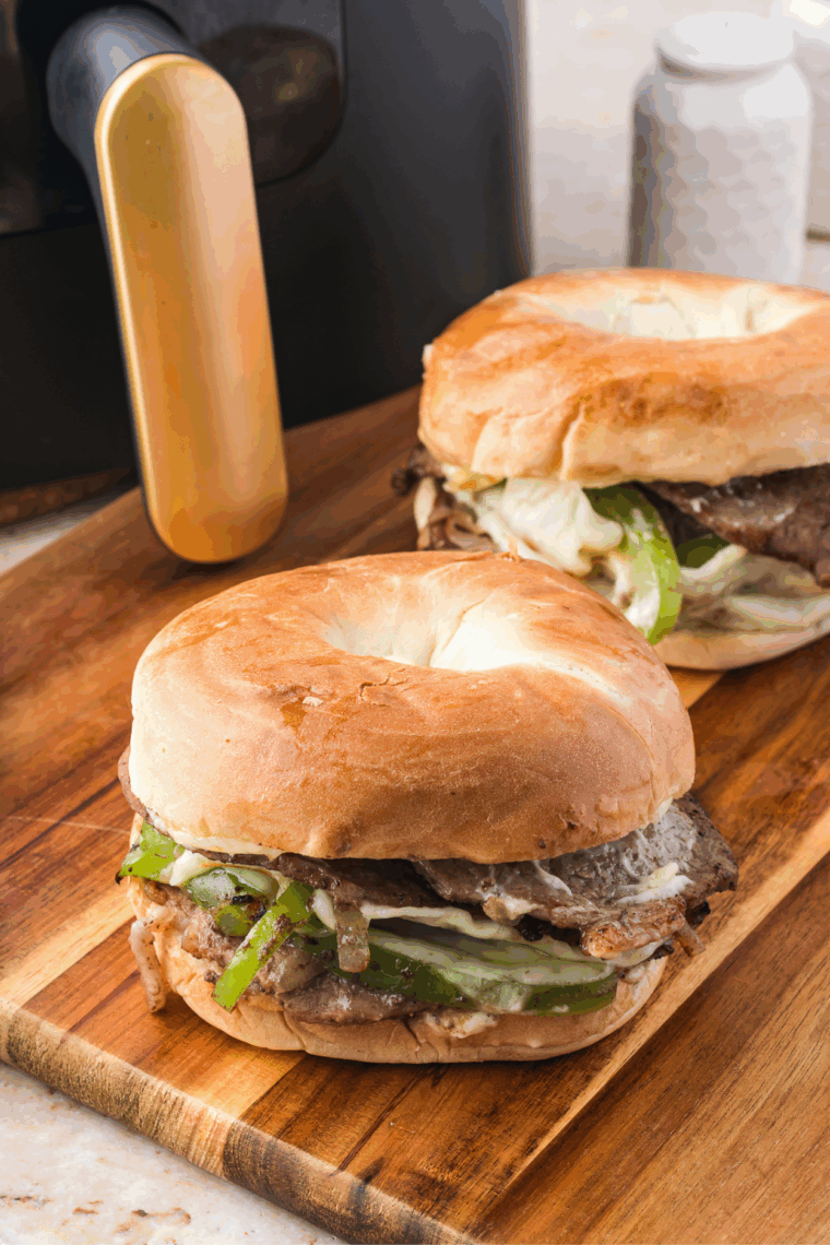 Ribeye steak sandwich on a toasted bagel with sautéed onions, peppers, and melted provolone cheese.