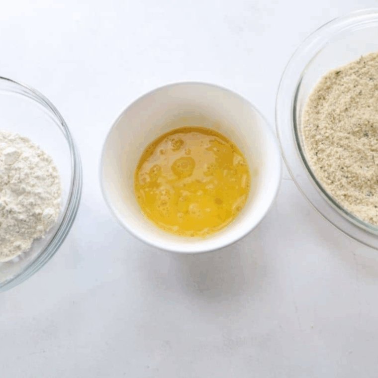 Prepare three dredging stations: flour in first bowl, eggs in second, Panko mixture in third for breading eggplant fries.