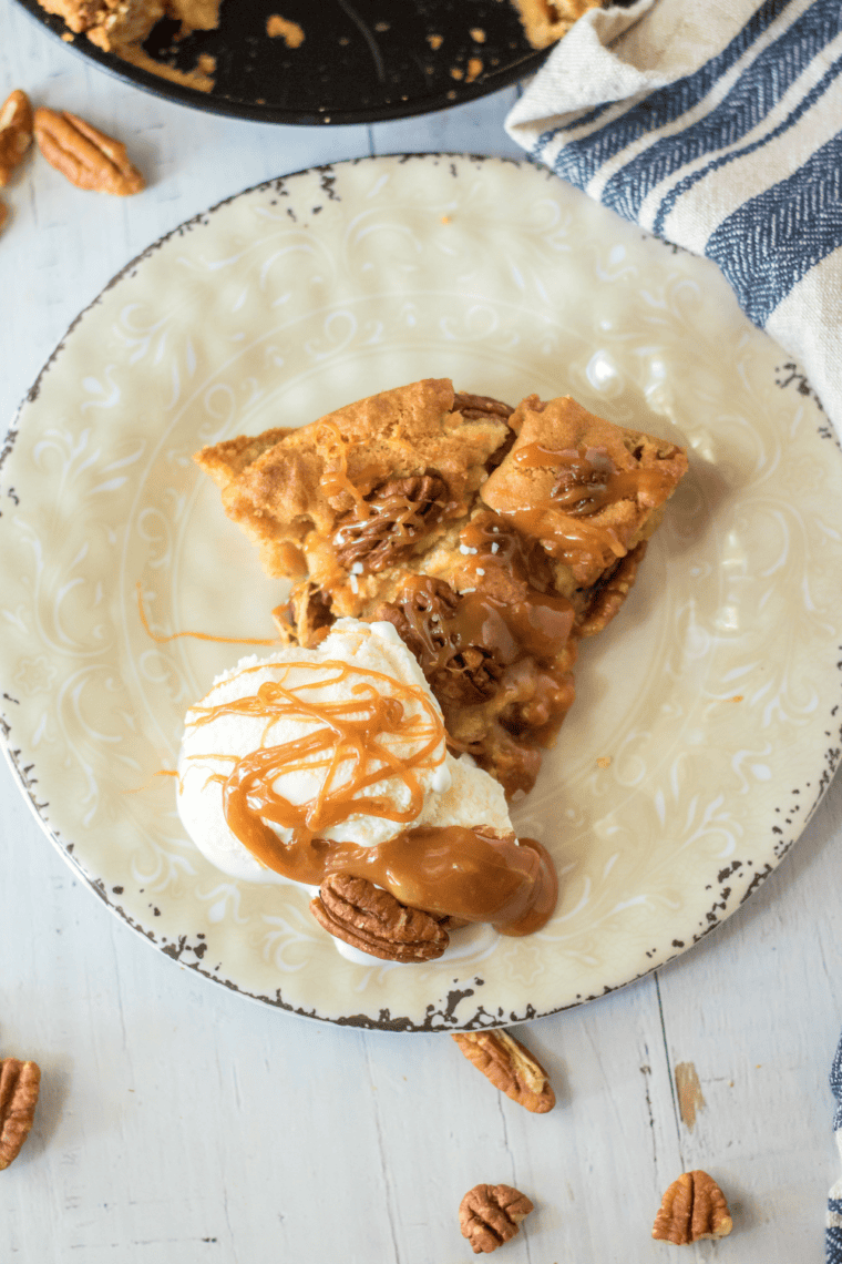 Giant Caramel Pecan Air Fryer Cookie fresh from the air fryer, topped with melted caramel and crunchy pecans