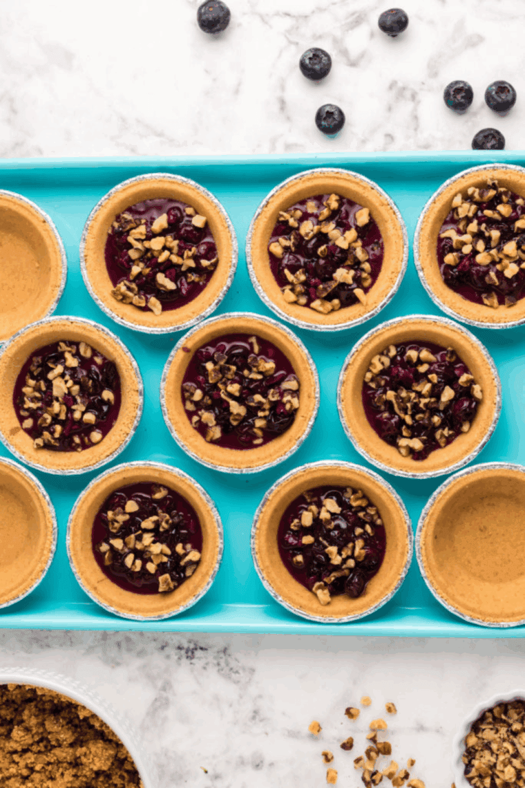 Blueberries, walnuts, and bourbon soaking together in a bowl before baking