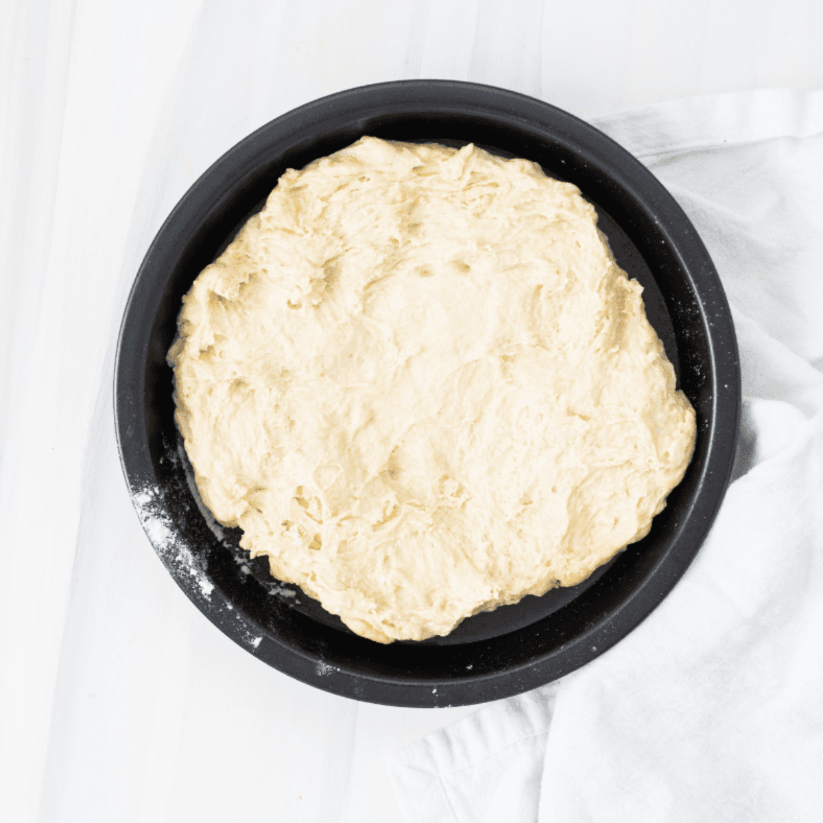 Mixing yeast, sugar, water, flour, and oil in a large bowl to form focaccia dough
