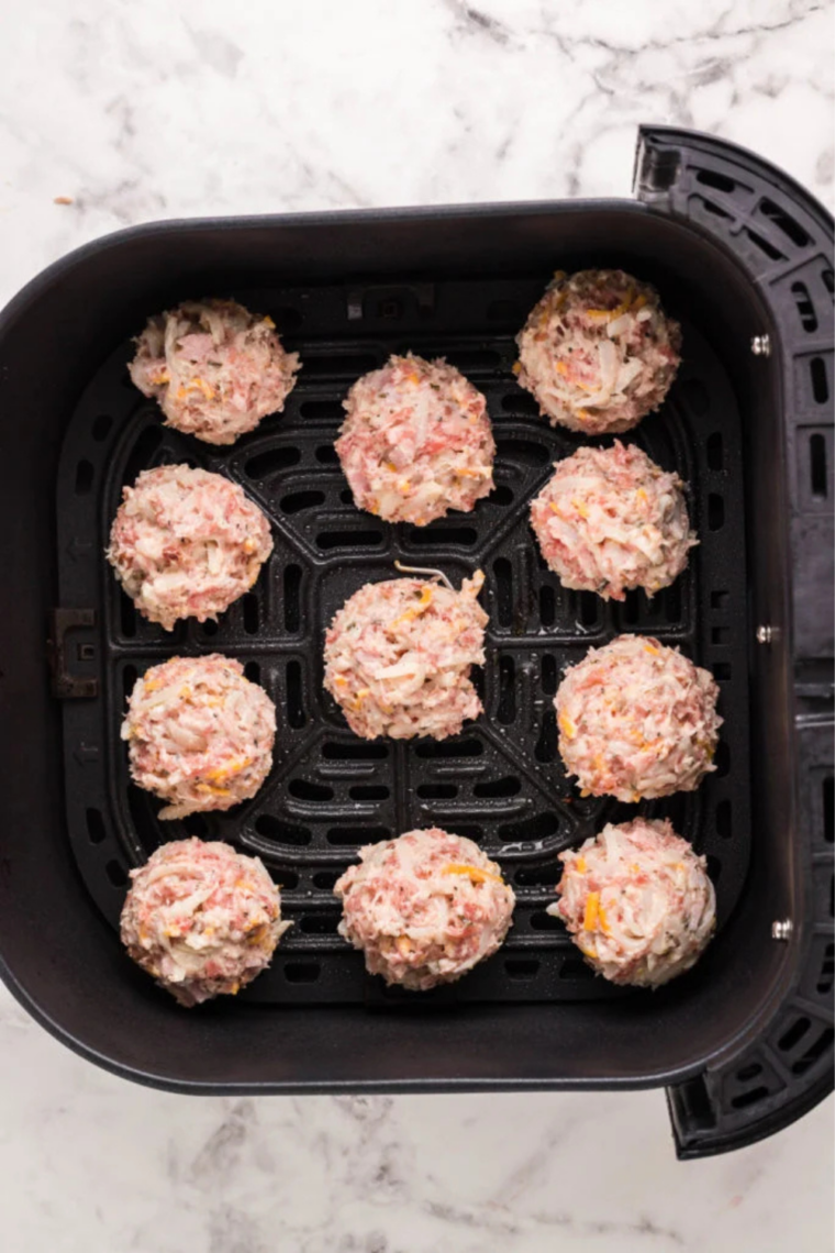 Air Fryer Sausage Balls arranged in a single layer in the air fryer basket before cooking