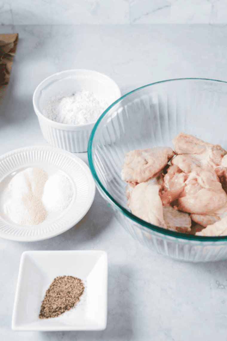 Chicken wings being patted dry with paper towels for crispy texture