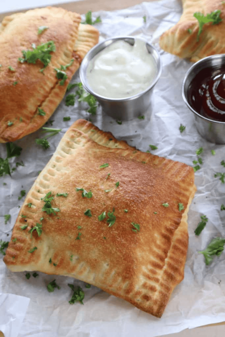 Air fryer BBQ chicken crescent rolls on a white plate with barbecue sauce for dipping