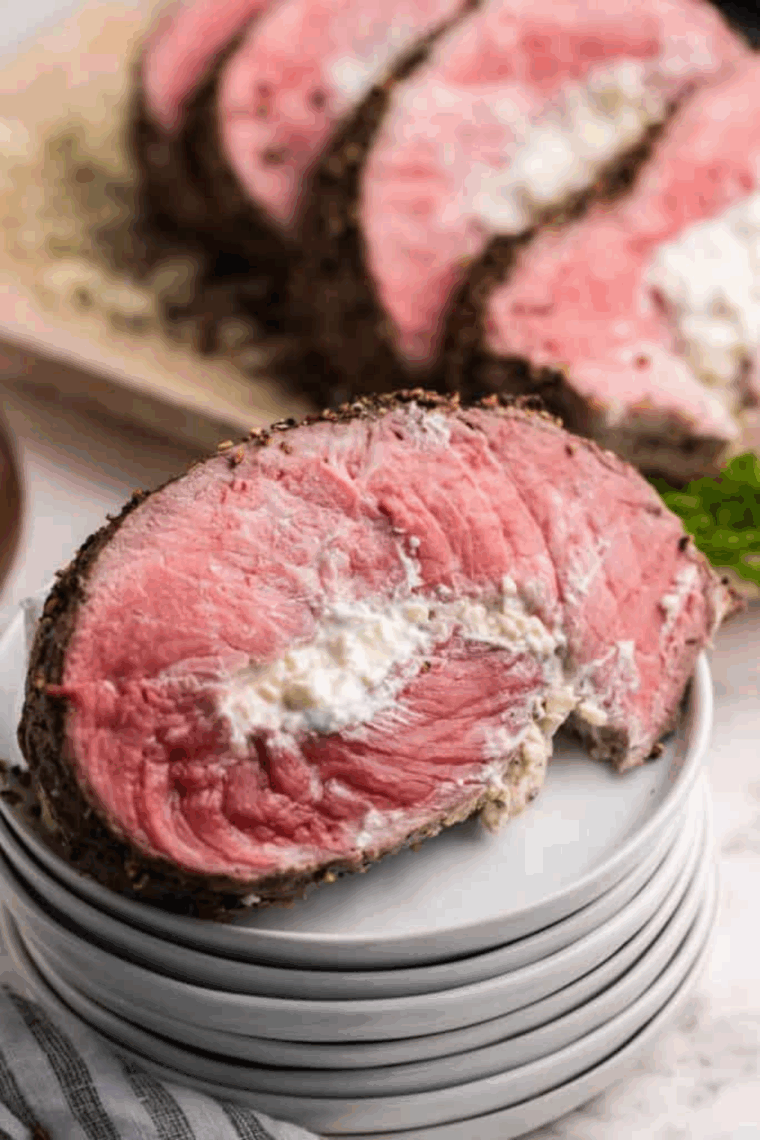 Sliced Black and Blue steak showing a dark, nearly black crust and a cool, bright red interior (blue-rare), served on a white plate.