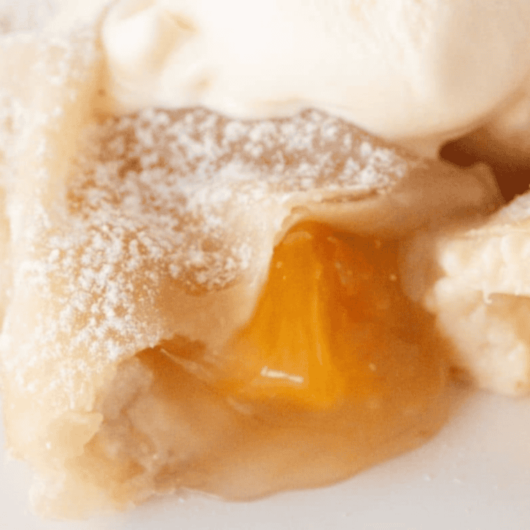 Golden, crispy air fryer peach cobbler egg rolls with creamy cinnamon-peach filling