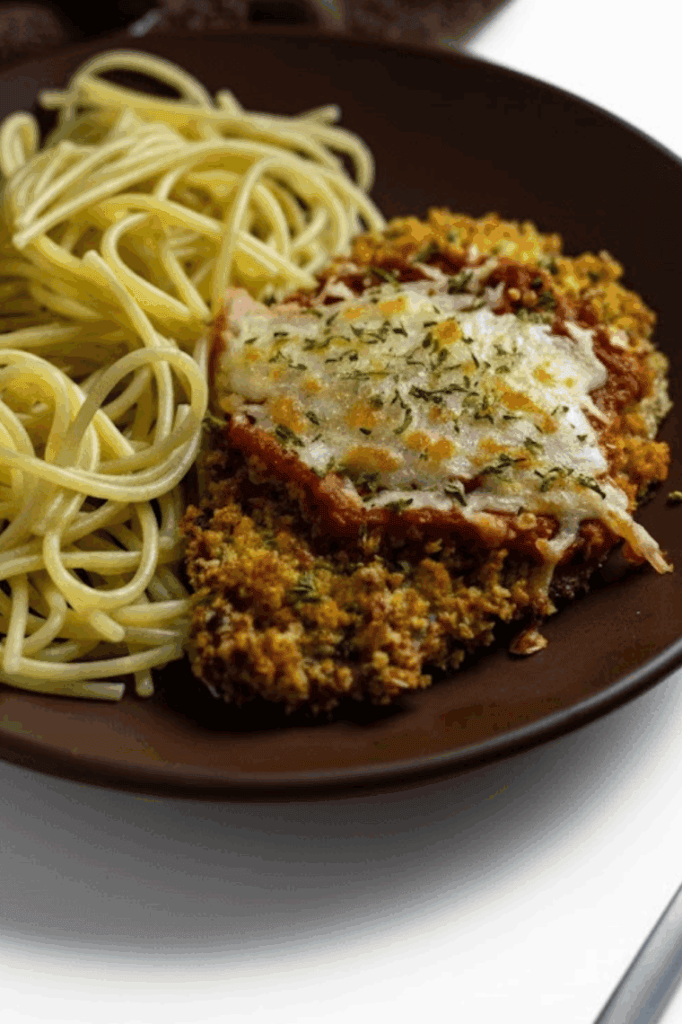 Crispy air fryer veal cutlets on a plate with marinara