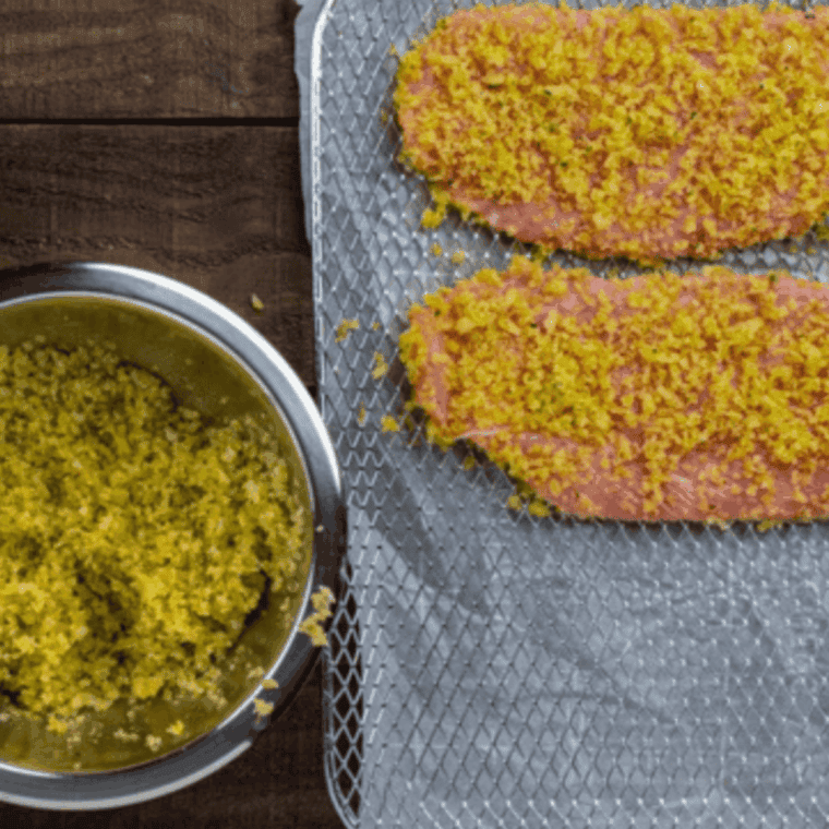 Thinning veal cutlets using a meat mallet to ensure they cook quickly and evenly in the air fryer.