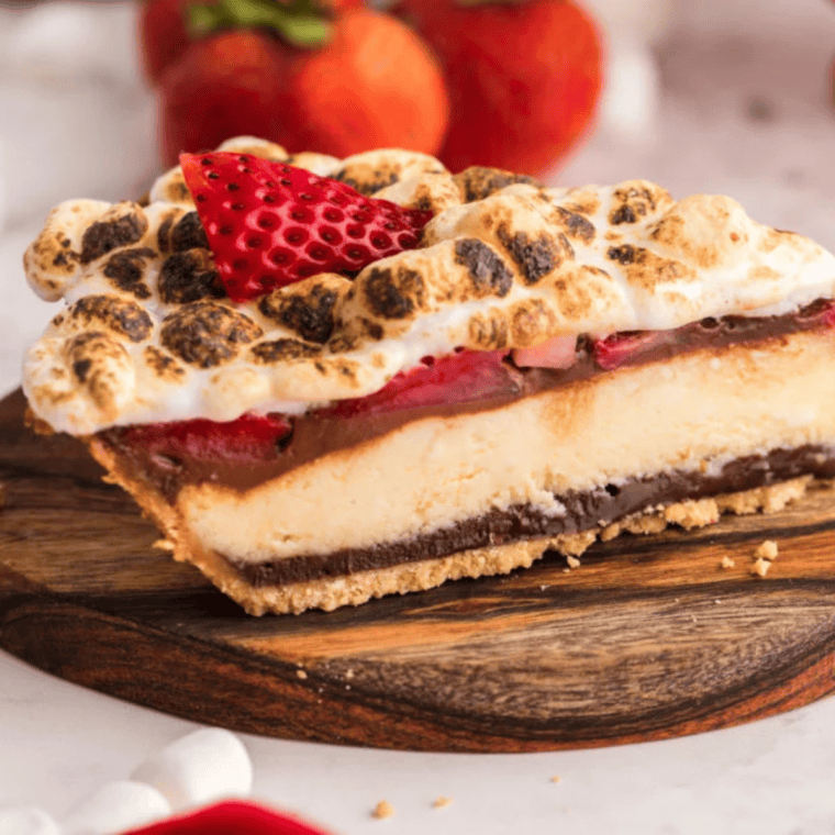 Air Fryer Berry S’mores Cheesecake with graham cracker crust, fresh strawberries, and golden toasted marshmallows on top.