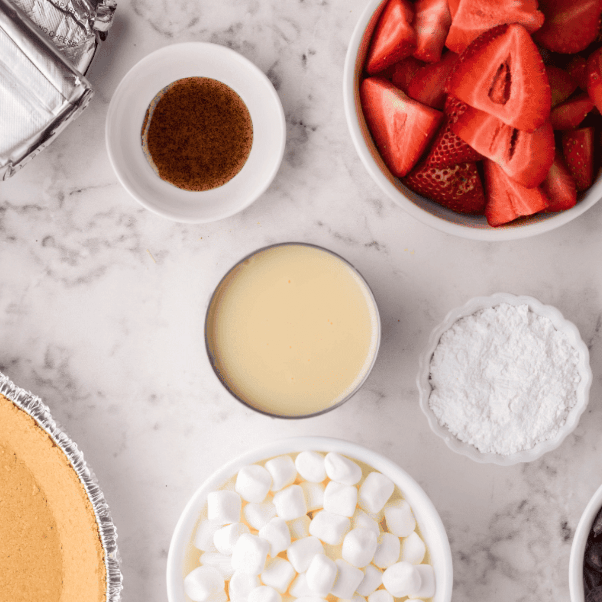 Ingredients needed for Air Fryer Berry S’mores Cheesecake on kitchen table.