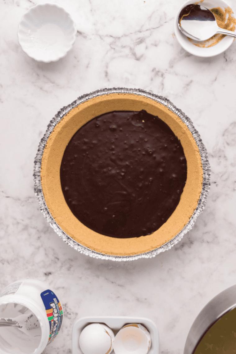 Melting chocolate chips with evaporated milk in a bowl, pouring over graham cracker crust and chilling in the fridge.