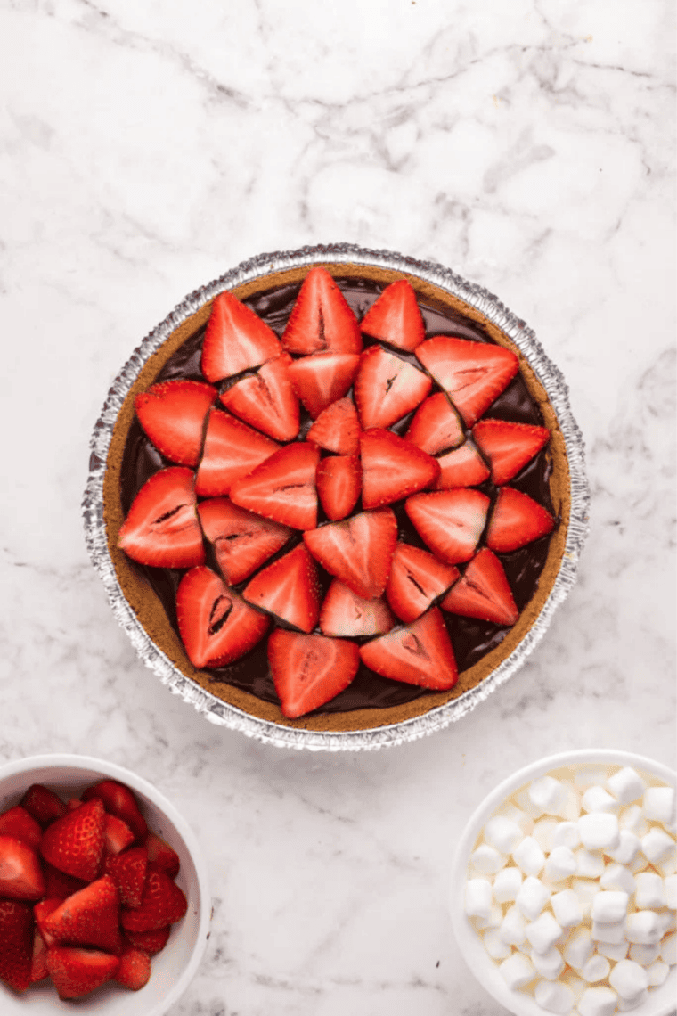 Air fryer cheesecake drizzled with chocolate and topped with sliced strawberries.