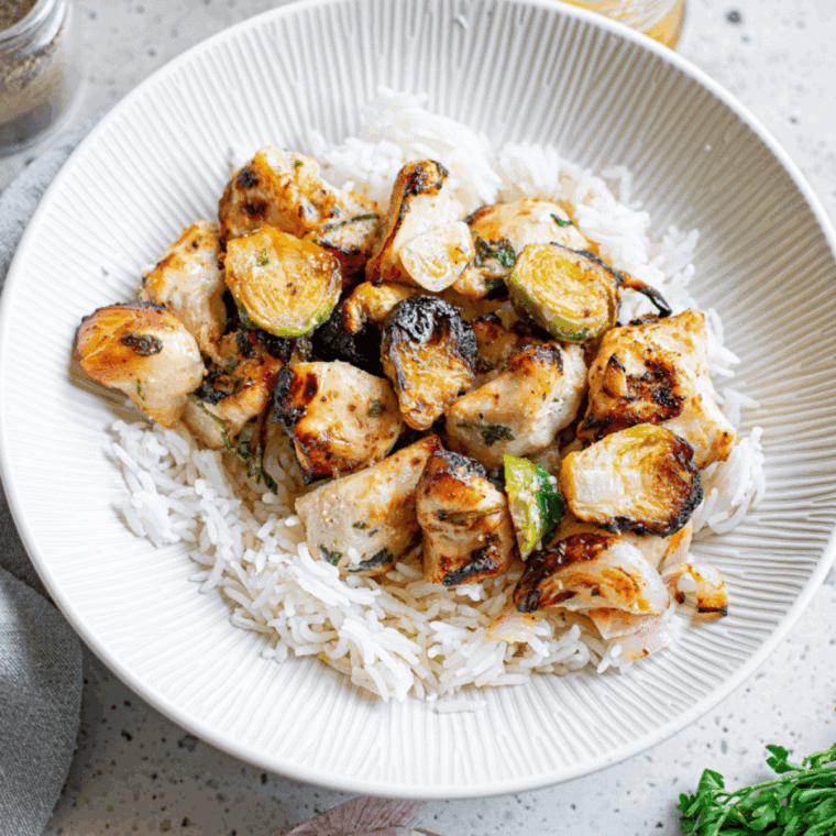 Air fryer chicken pieces and Brussels sprouts cooked until golden and crispy in a basket.