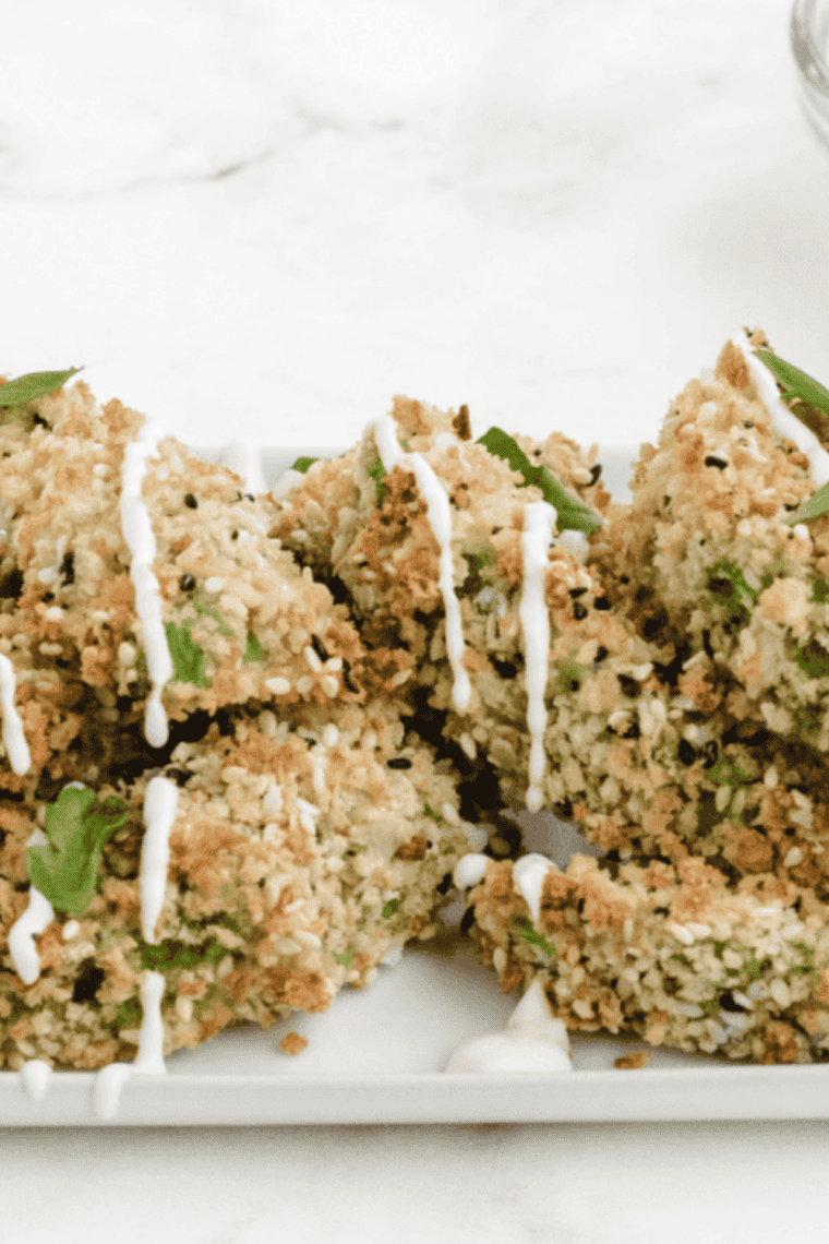 creamy melted cream cheese dressing being poured over air fryer avocado fries