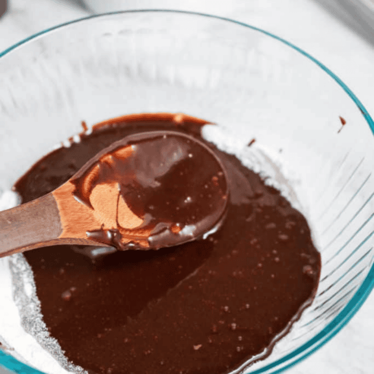 Dry brownie ingredients whisked together in a bowl with cocoa powder, flour, and sugars