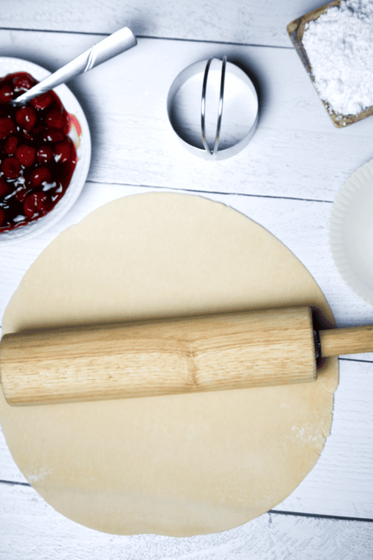 Rolling out pie crust with a rolling pin, keeping it slightly thick