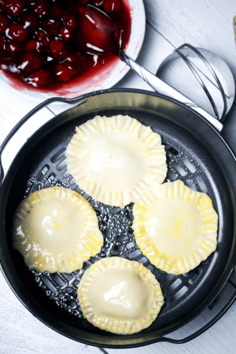 Beating egg with water for egg wash and brushing on pies before air frying until golden and crispy