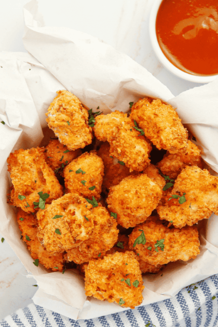 Golden, crispy air fryer popcorn chicken pieces on a plate, ready to serve.