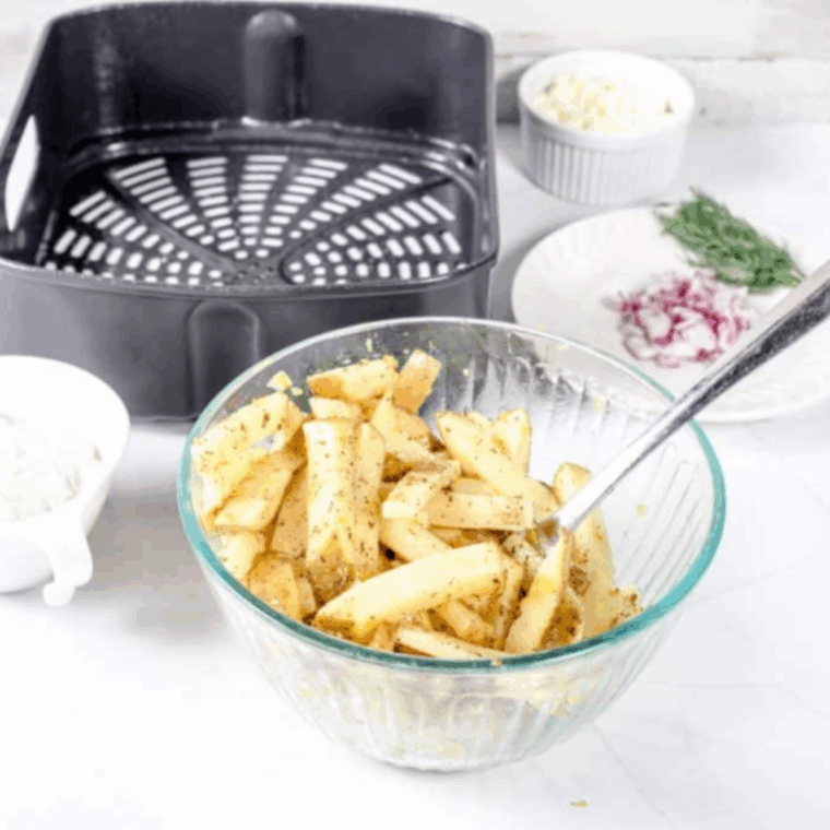 Toss sliced potatoes in the bowl with olive oil and seasoning.