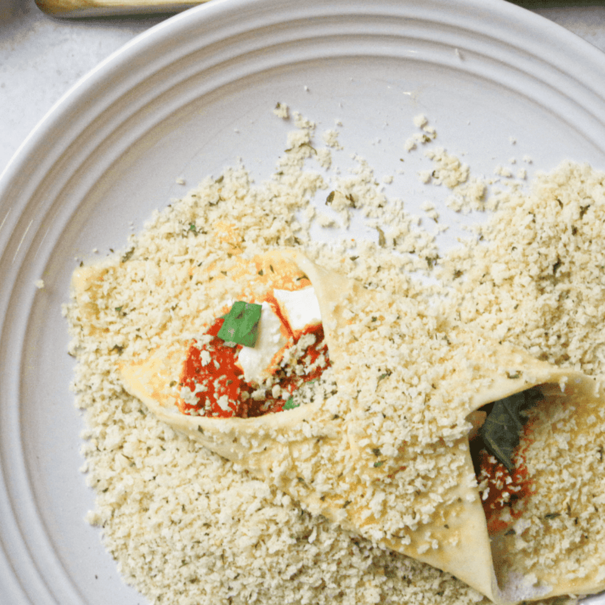 Pizza cannoli coated in panko crumbs and sprayed with olive oil, ready to air fry until golden brown.