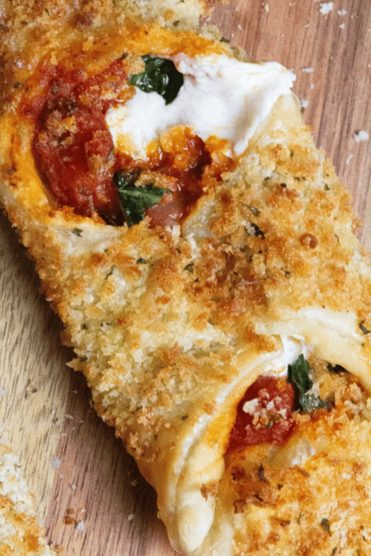 Golden, crispy Air Fryer Pizza Cannoli filled with melted mozzarella, tomato sauce, and fresh basil on a serving plate.