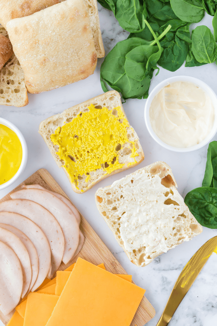 Preparing turkey and cheese sandwiches with mayonnaise and mustard before air frying