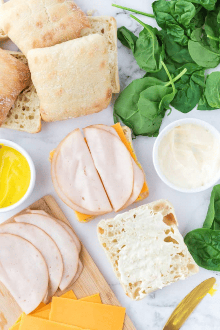 Air frying a turkey and cheese sandwich until golden, with optional butter or cooking spray on the bread exterior