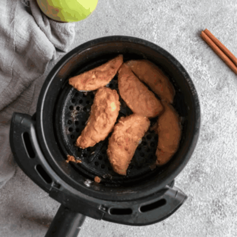 Cooked apple fries in the air fryer basket.