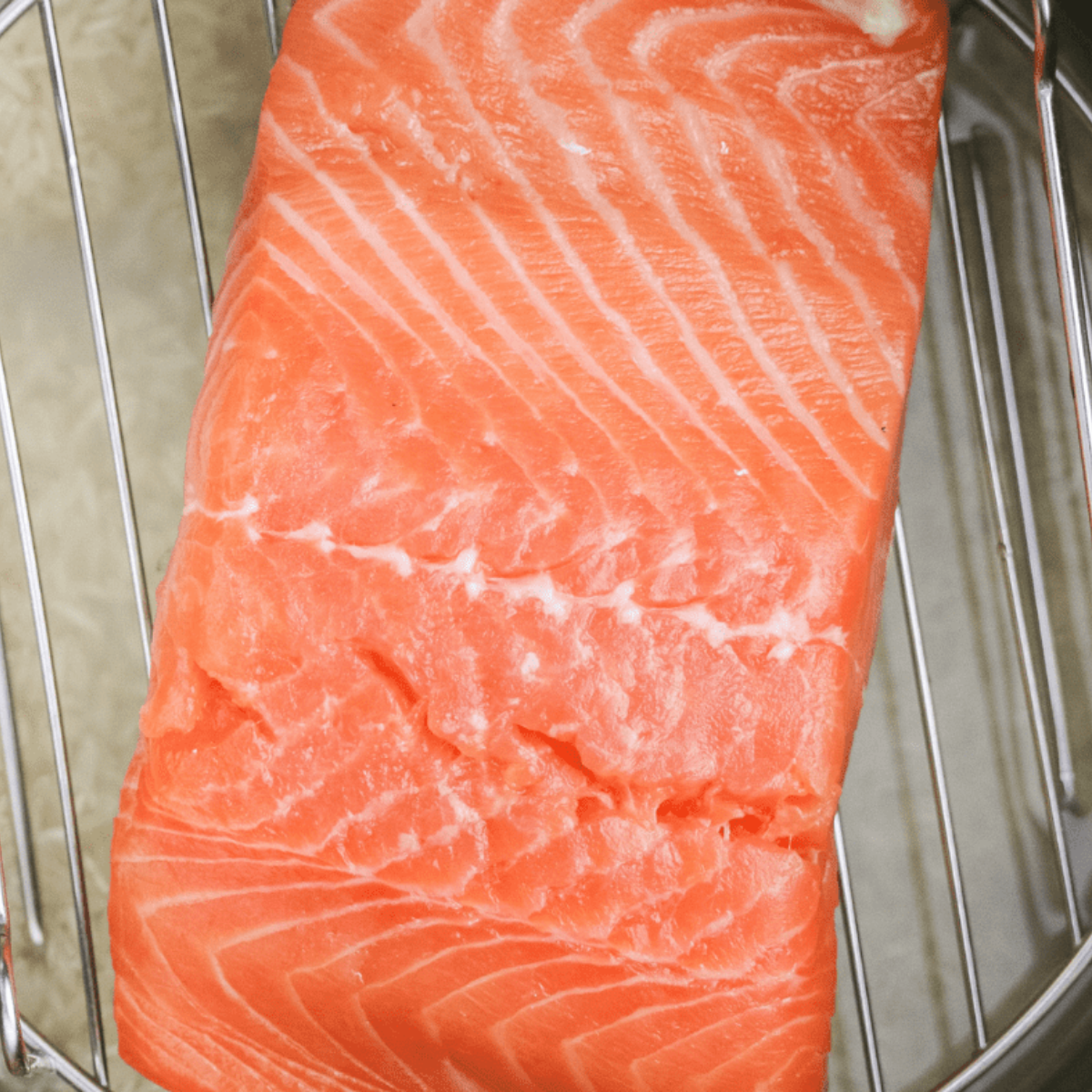 Adding rinsed jasmine rice, sprinkling dill, drizzling lemon juice, and pouring broth over salmon and vegetables.