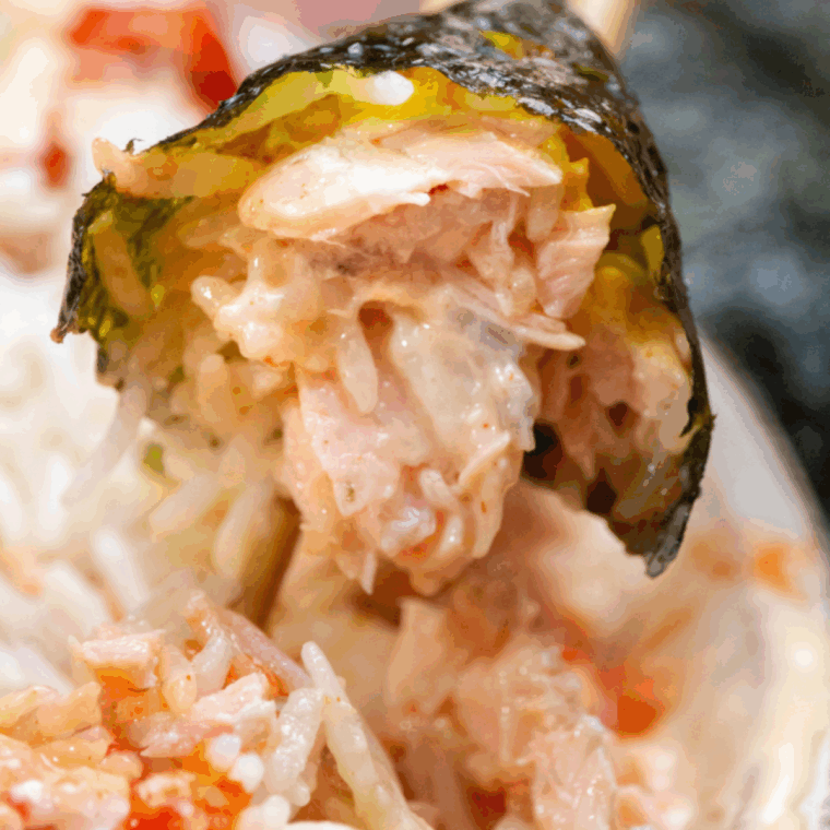 Close-up of homemade salmon sushi rolls with avocado and rice on a cutting board