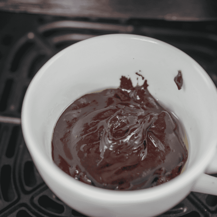 Folding chocolate chips into brownie batter, then pouring the mixture into a prepared ramekin or small pan before cooking.