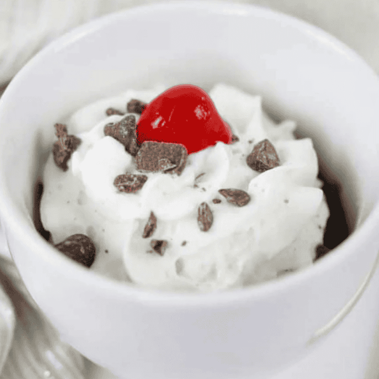Single serve air fryer brownie baked in a ramekin with a gooey center, crackly top, and melted chocolate chips.