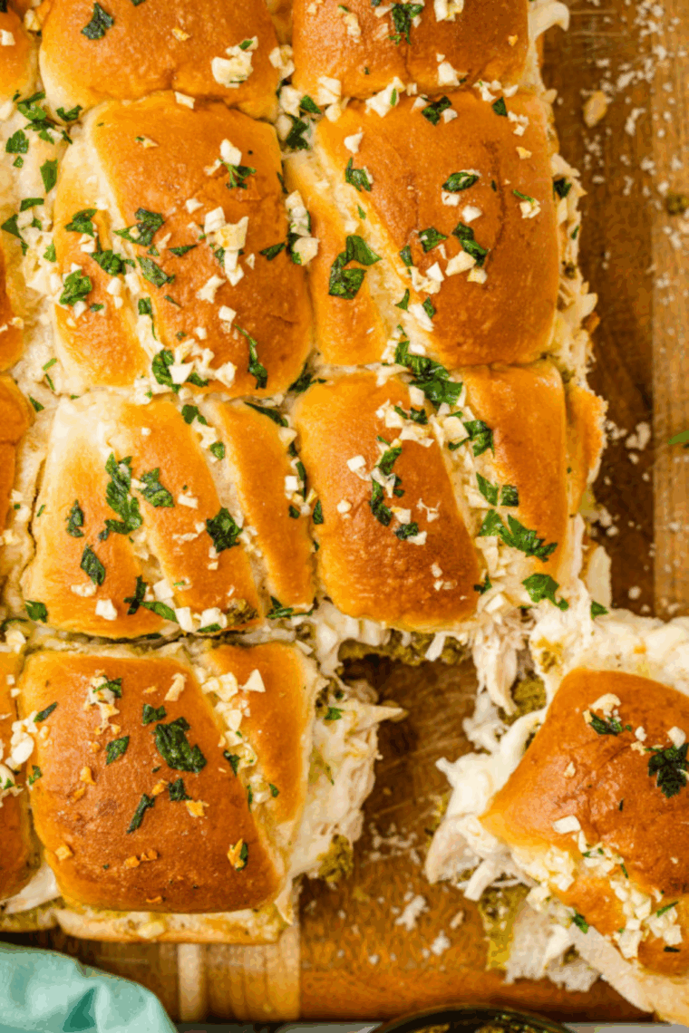 A plate of golden-brown air fryer chicken pesto sliders with melted mozzarella cheese and a vibrant green pesto layer.