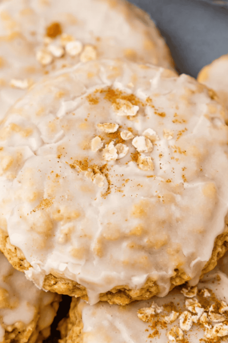 Plate of Air Fryer Copycat Crumbl Iced Oatmeal Cookies with creamy white icing and golden-brown edges.