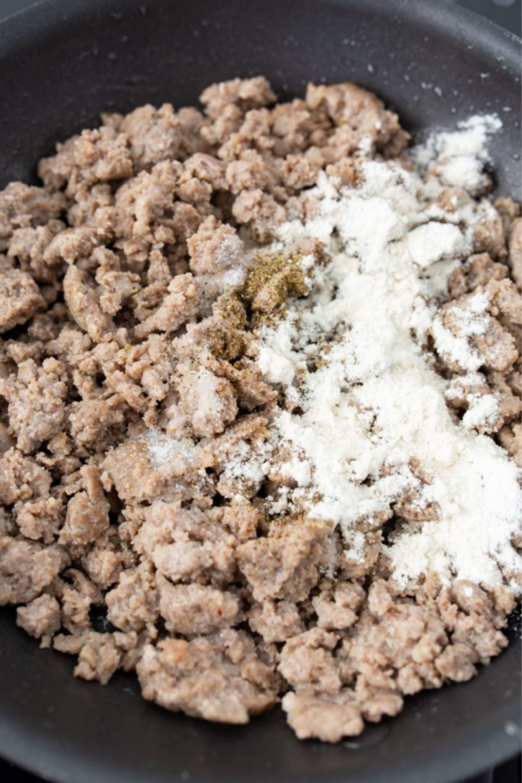 Ground breakfast sausage browning in a medium skillet on the stovetop