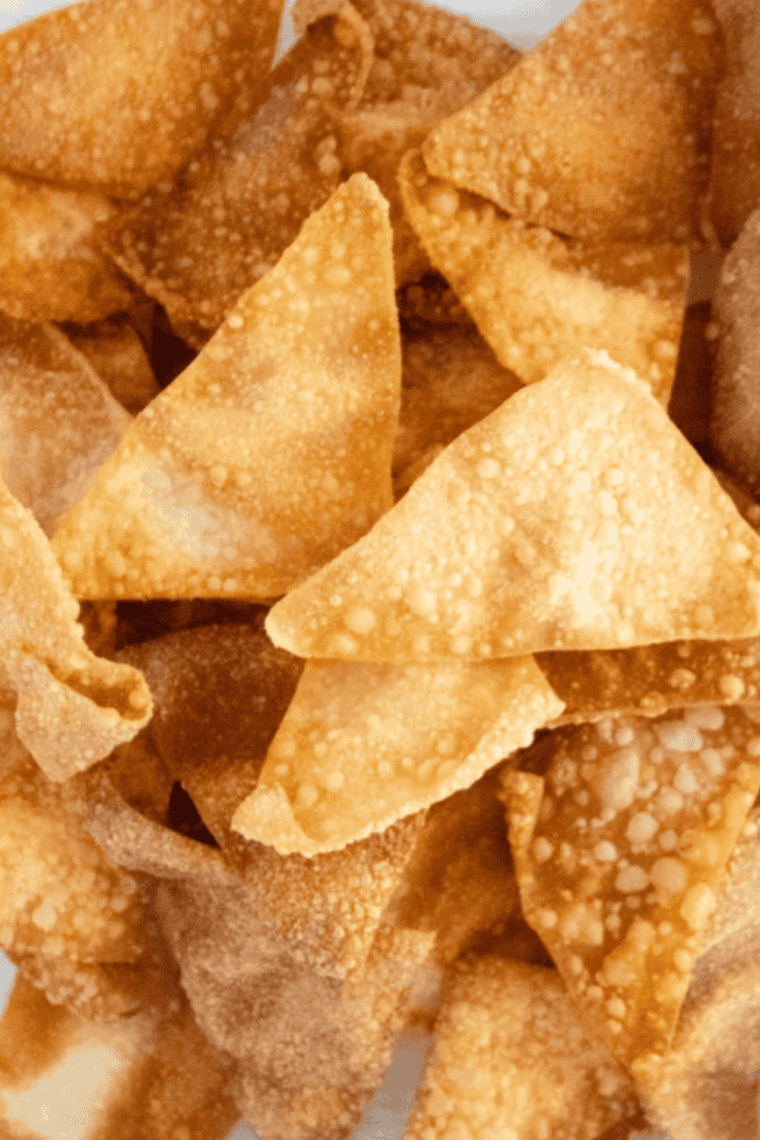 A bowl of homemade air fryer wonton chips, cut into triangles and lightly salted
