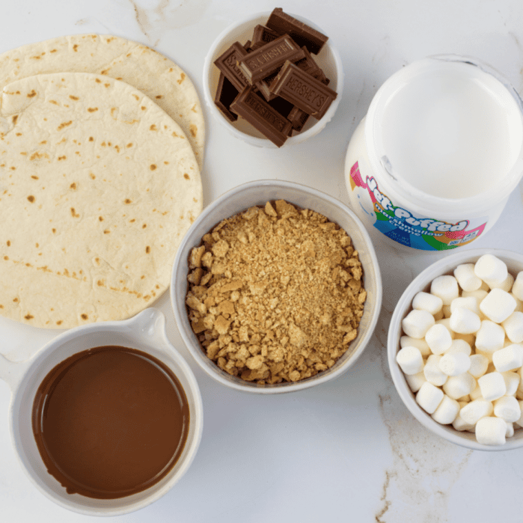 Ingredients needed for Easy Blackstone Grill S&rsquo;mores Pizza on kitchen table.