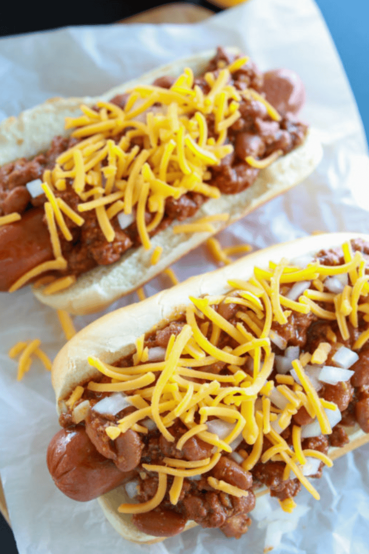 Juicy hot dogs sizzling on a Blackstone griddle with crispy, browned edges and grill sear marks cooking on a flat top.