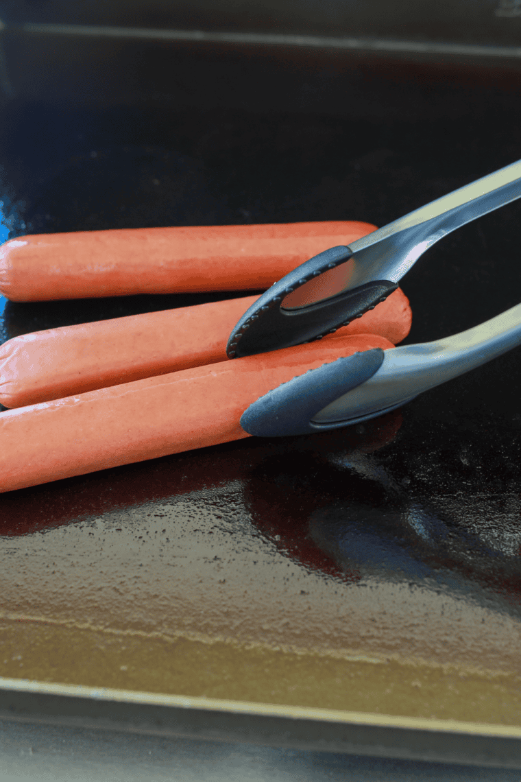 Place scored hot dogs on griddle, spacing evenly for even cooking.