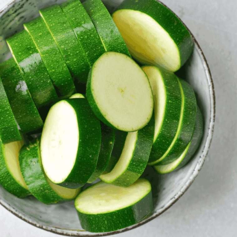 Rinsing fresh zucchini and slicing into ¼-inch thick rounds for air fryer chips.
