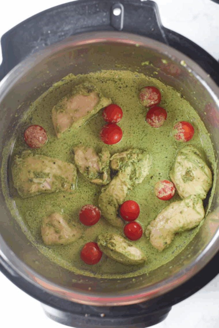 Pesto-coated chicken saut&eacute;ing in the Instant Pot with a bit of oil, ready to be deglazed with chicken stock