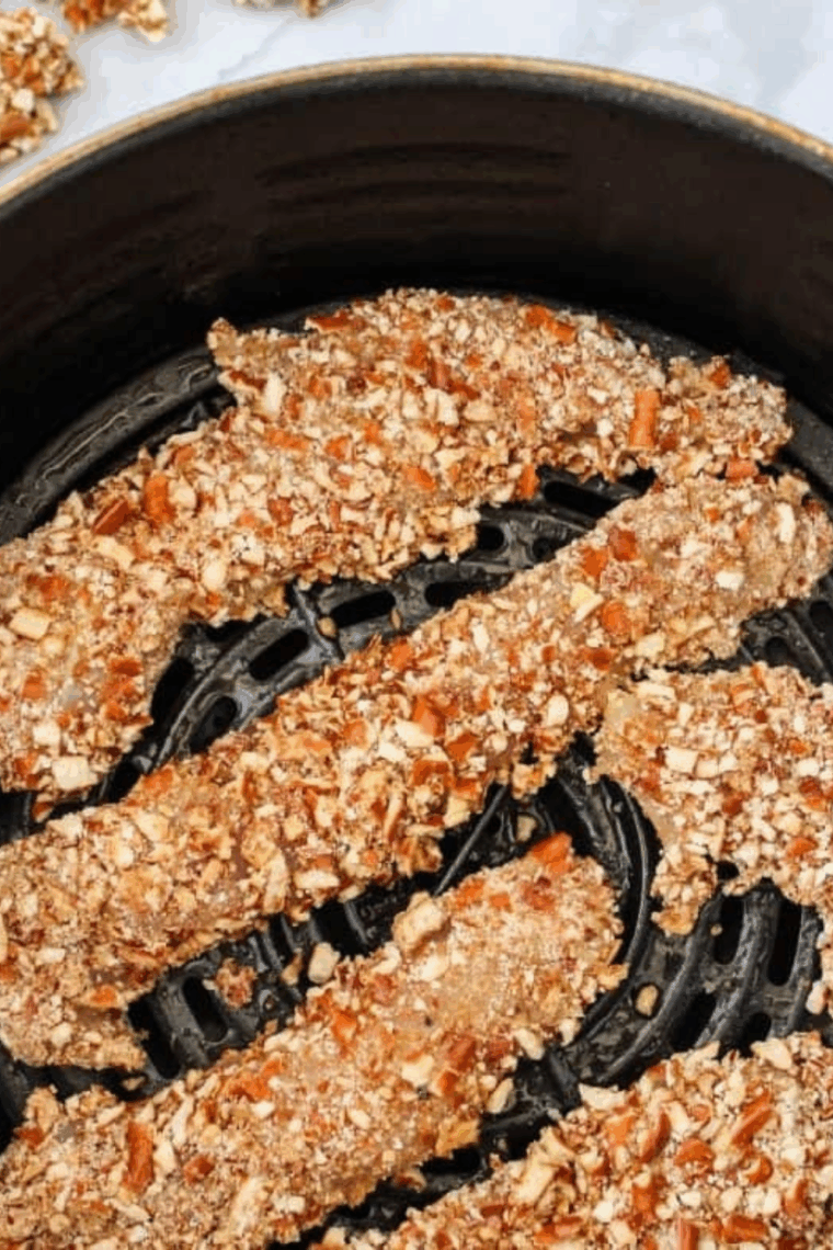 Coated Pretzel Crusted Chicken Tenders in air fryer basket.