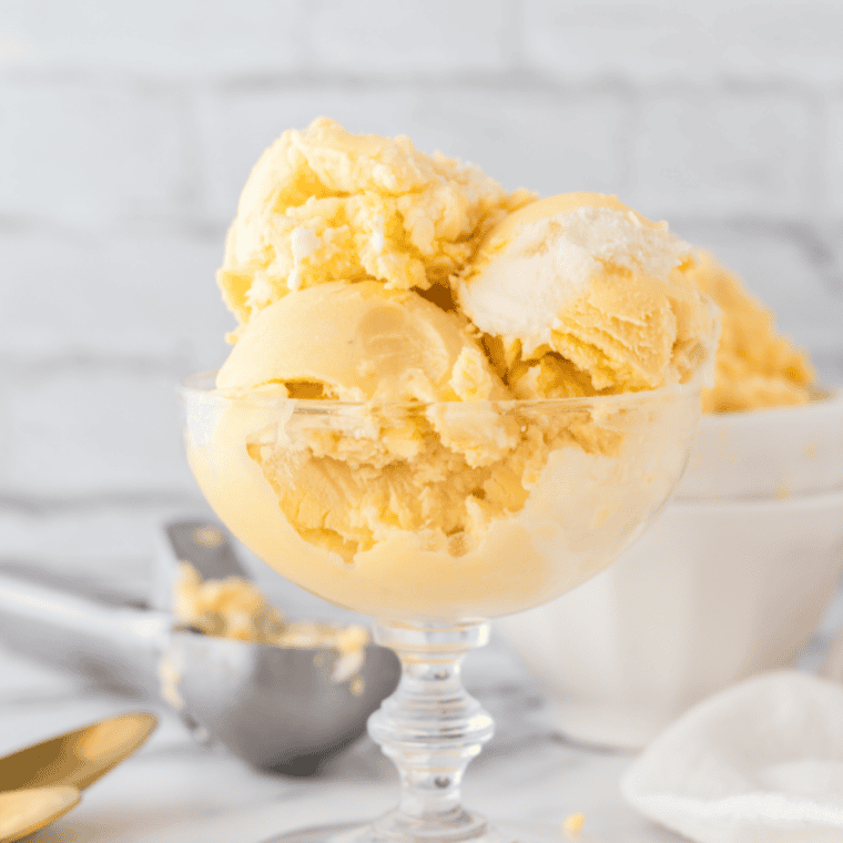 A bowl of creamy peach ice cream made in the Ninja Creami, naturally sweet and sugar-free.